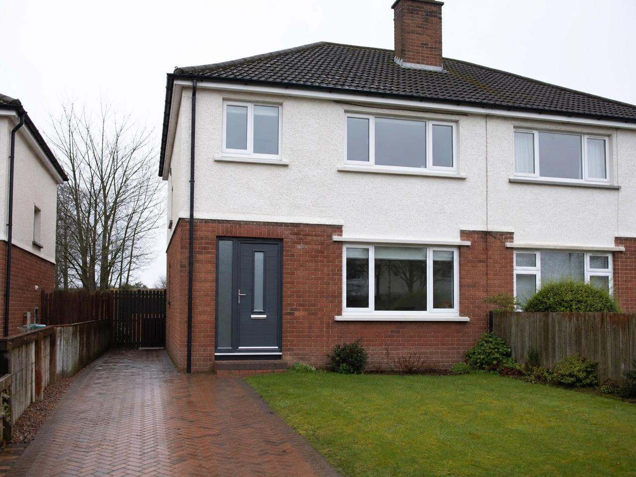 Scottish home fitted with white uPVC windows and a grey composite front door